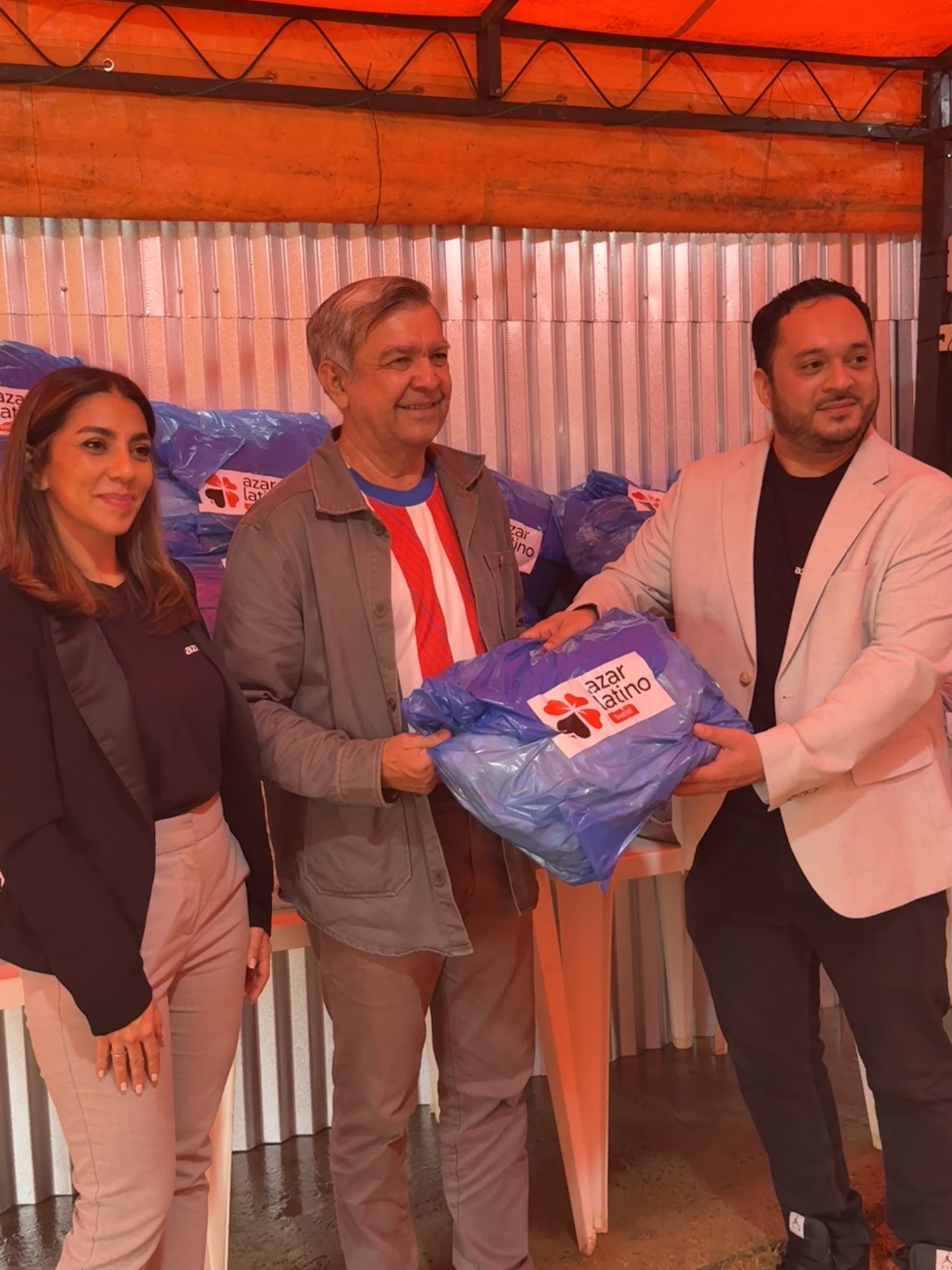 Representantes de Azar Latino Social durante una entrega solidaria