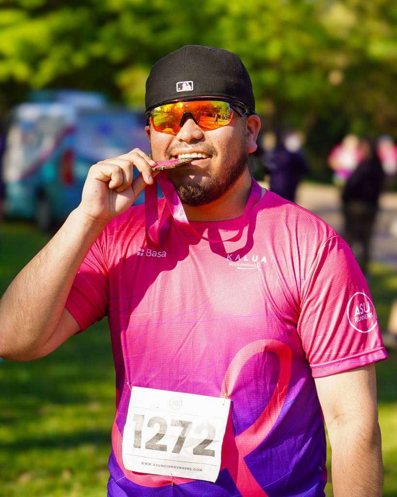 Participante de Azar Latino Social con su medalla de la Corrida Octubre Rosa.